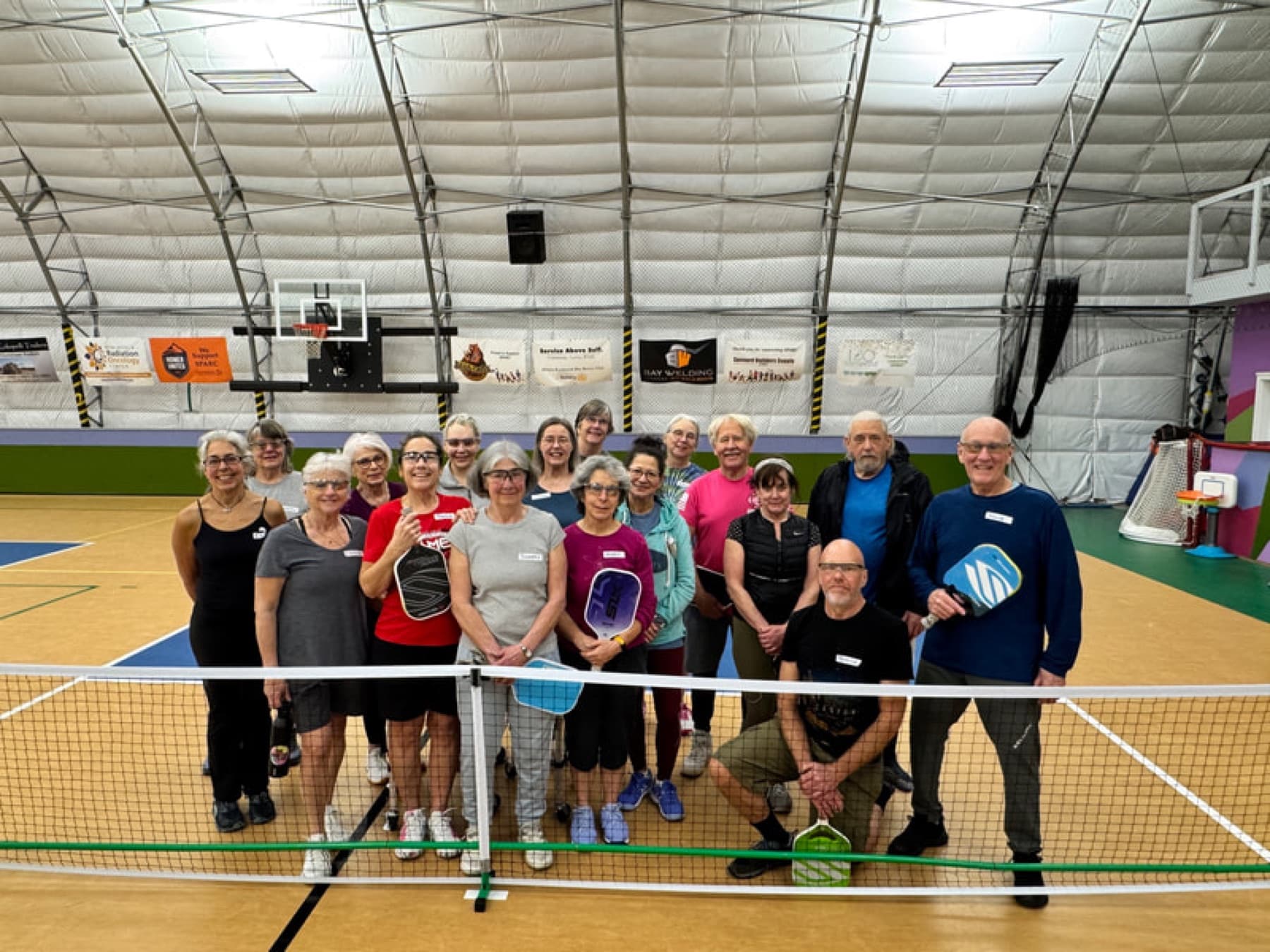 A beginner group working at the net during a clinic
