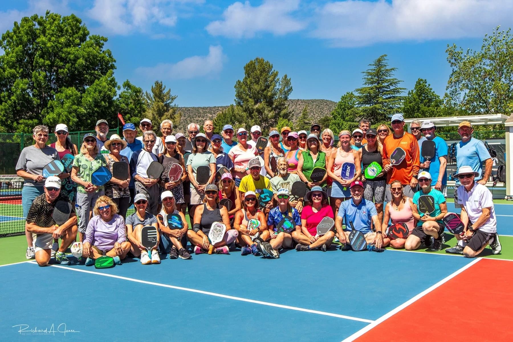 A large group of players on a sunny court