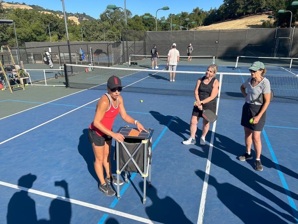 Carmen coaching two players at the tactics board